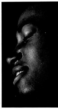 A beautiful photograph of a side view of a black man's serene face.