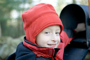 A picture of a little boy reaching into his mail box with anticipation.